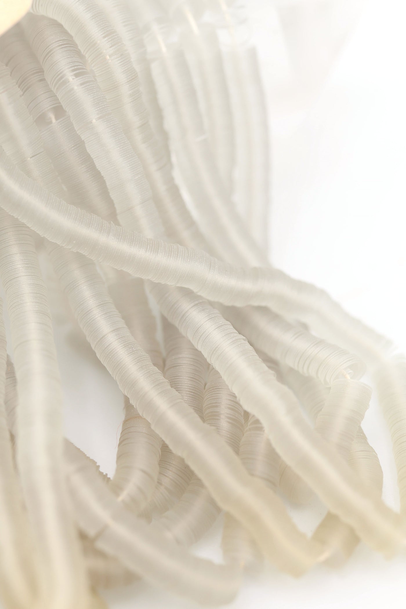 Hank of clear grey vintage French sequins draped so their iridescent faces are showing.