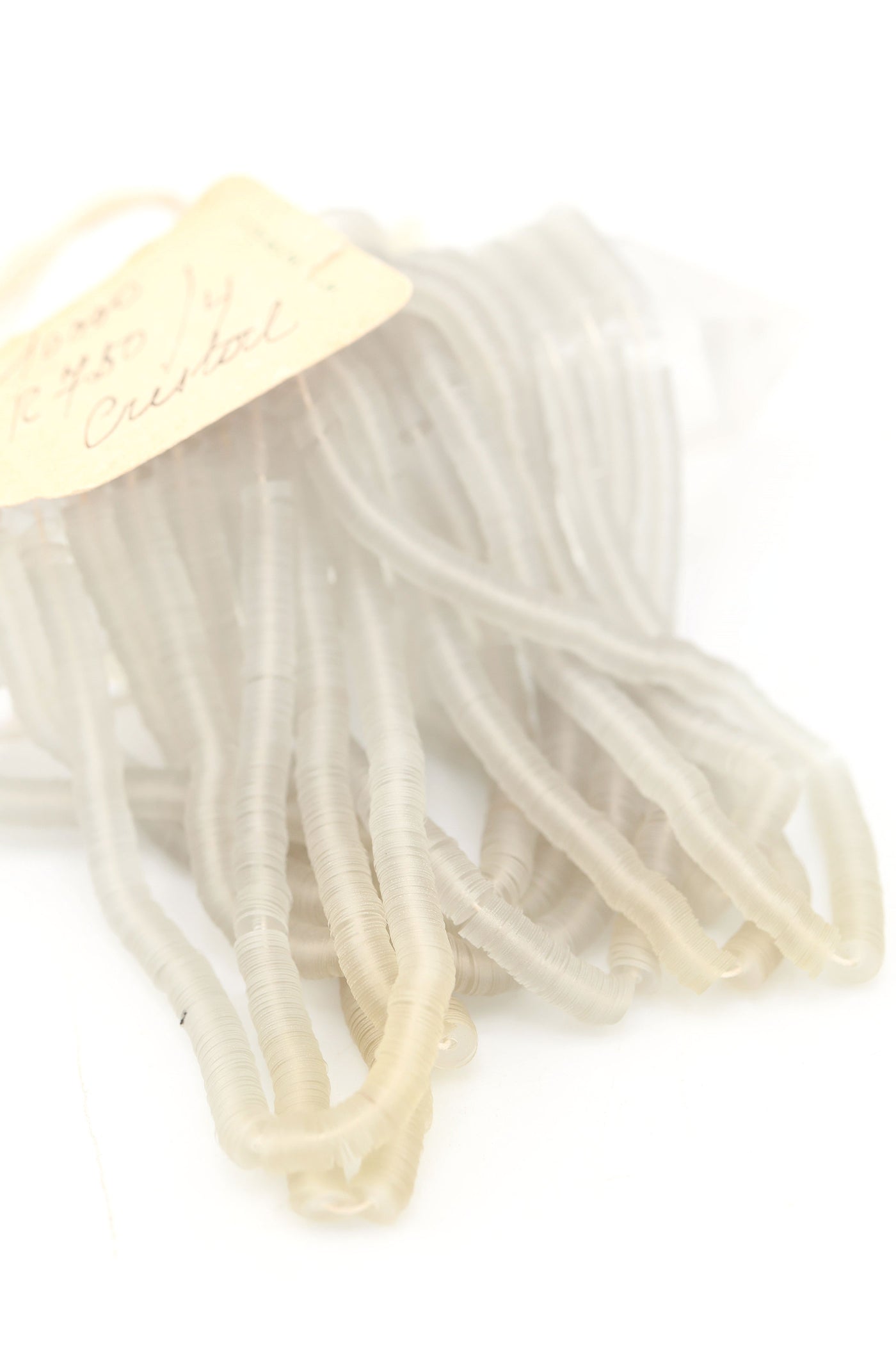 Hank of clear grey vintage French sequins draped so their iridescent faces are showing.