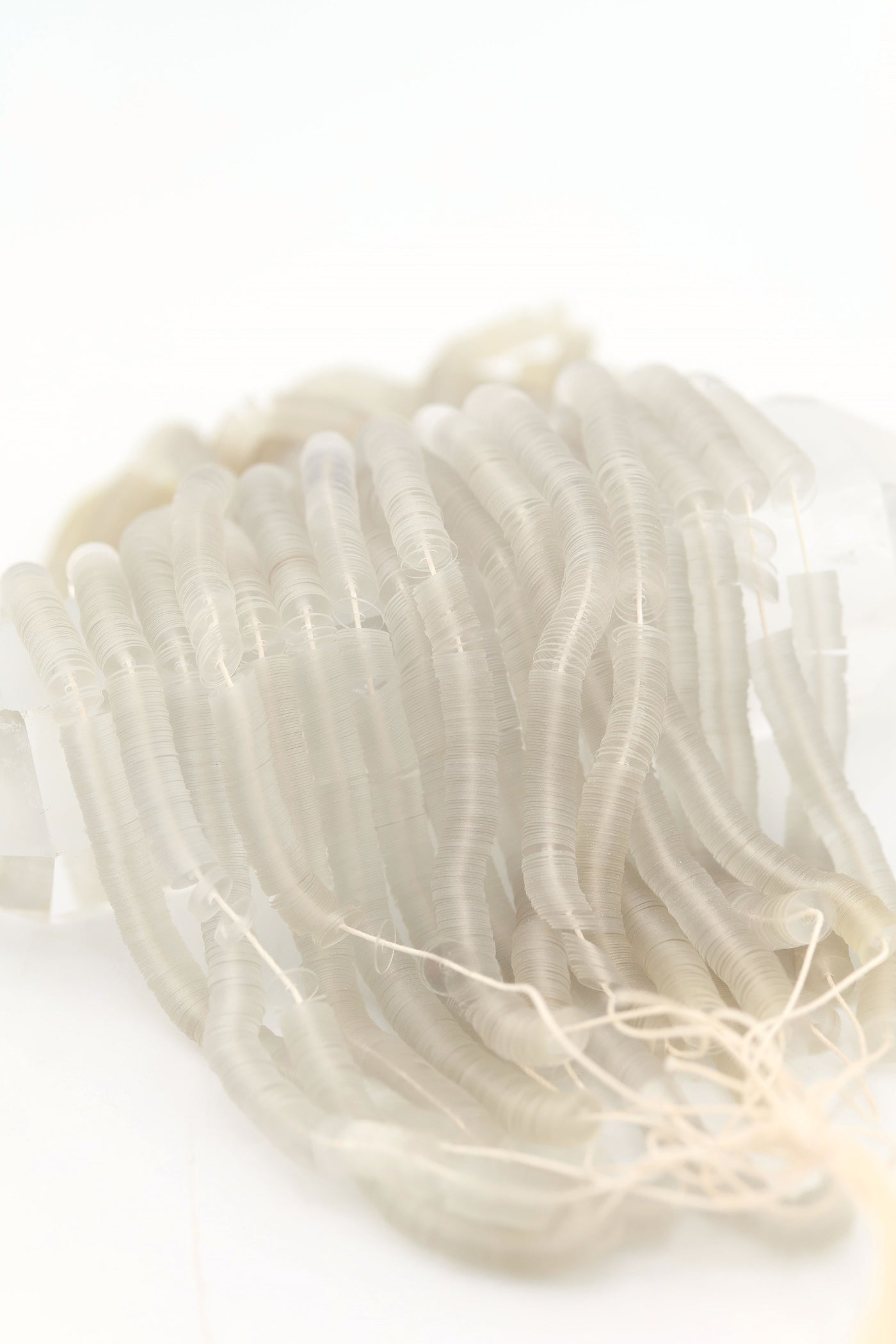 Hank of clear grey vintage French sequins draped so their iridescent faces are showing.