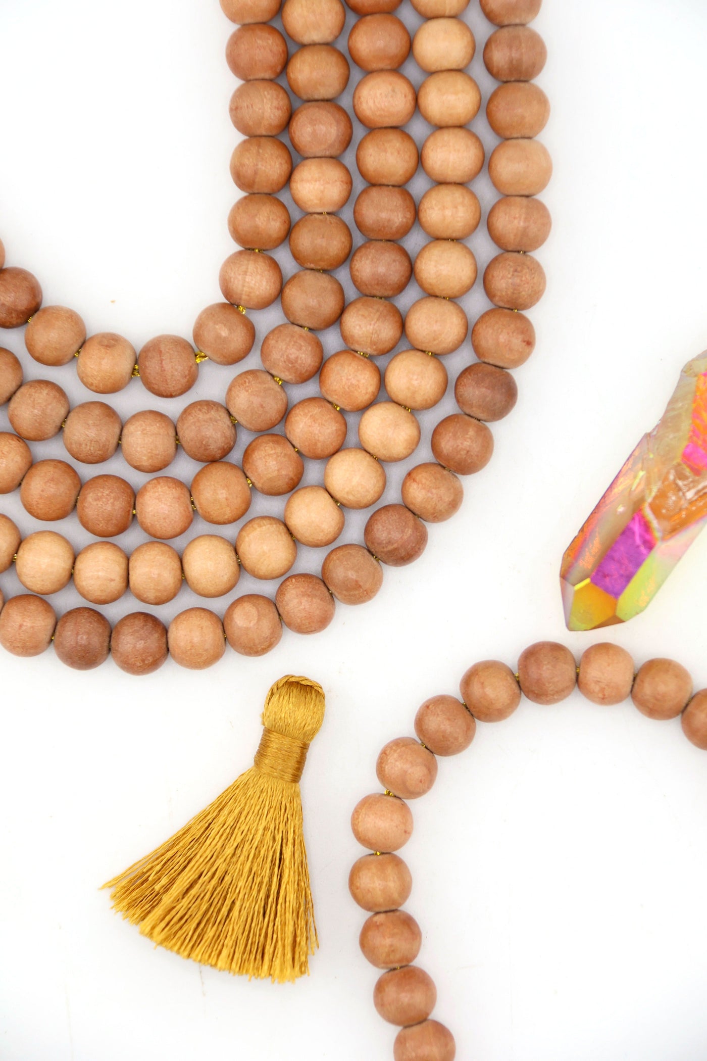 Close-up of natural 8mm wood beads in earthy brown tones, arranged in strands on white background.