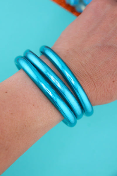 Stack of waterproof Aqua Luxe Thai Bangles in vibrant aqua blue, chunkier version of classic temple bracelets.