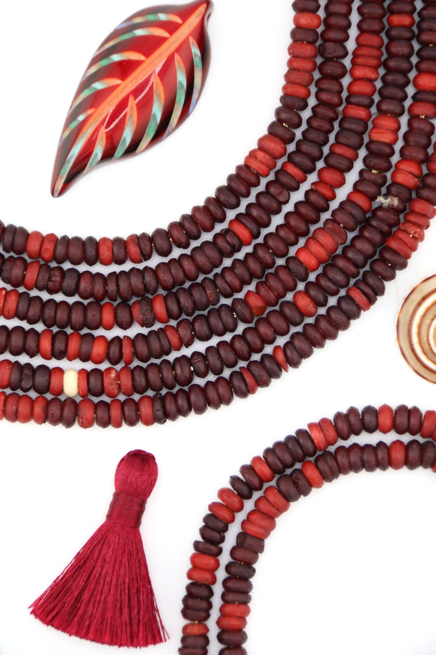 Close-up of small 6x3mm burgundy bone heishi beads with natural matte texture, handmade.