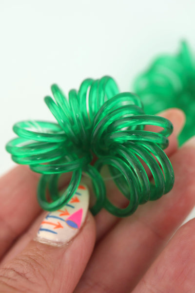 Translucent 18mm Green Vintage German Resin Rings in a bundle, in a hand with a painted fingernail
