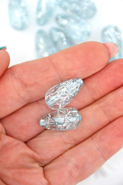 Hand holding 2 Ice Blue Glitter Italian Resin Teardrop Beads