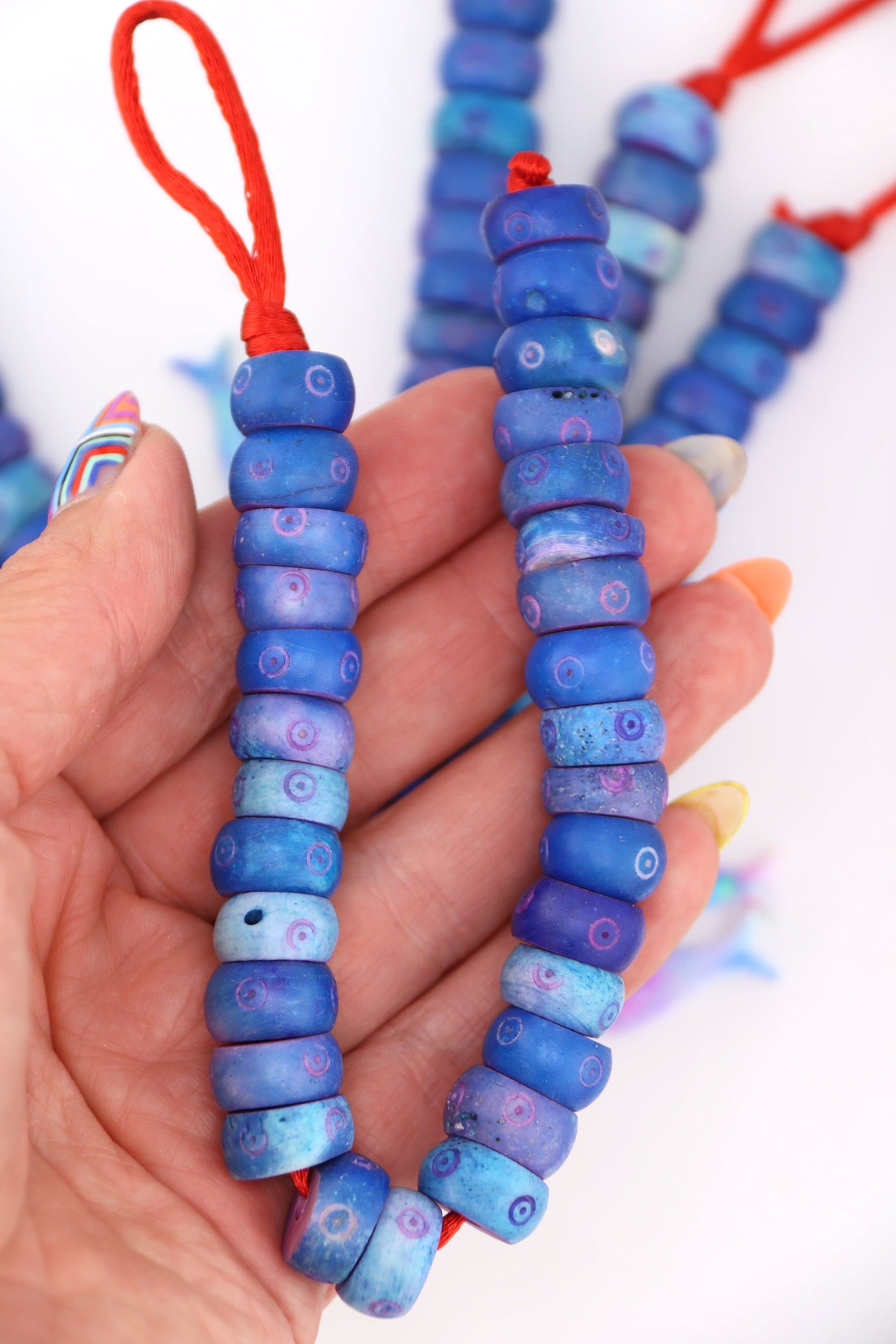 Artisanal blue bone beads with carved bullseye details, donut shape, ideal for bold DIY jewelry making.