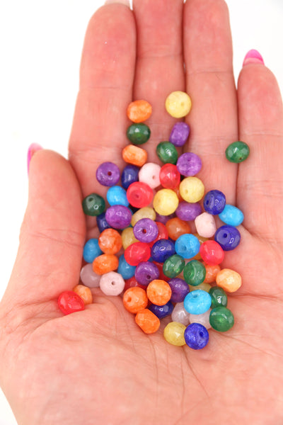 Colorful selection of beads in the palm of a hand, for making DIY colorblock necklace