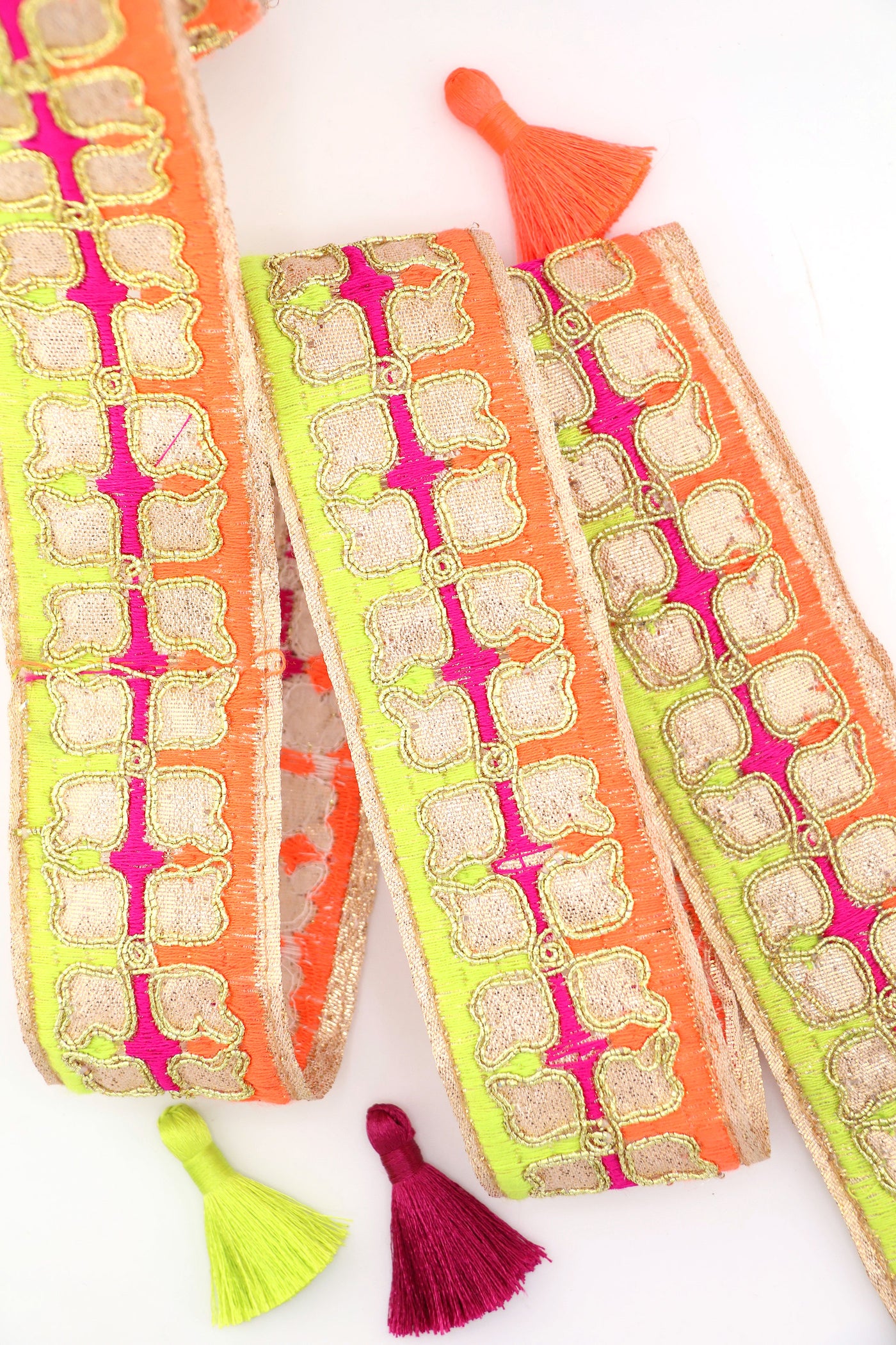 Neon embroidered sari trim with clover design and gold metallic thread. Great for sewing, crafting, embellishment, and DIY decor. Sold by the yard.