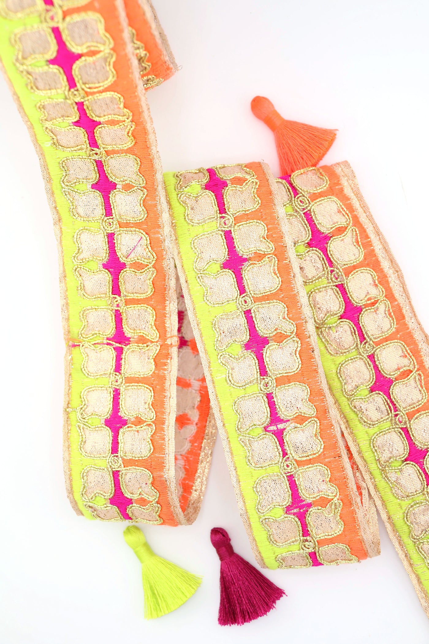 Neon embroidered sari trim with clover design and gold metallic thread. Great for sewing, crafting, embellishment, and DIY decor. Sold by the yard.
