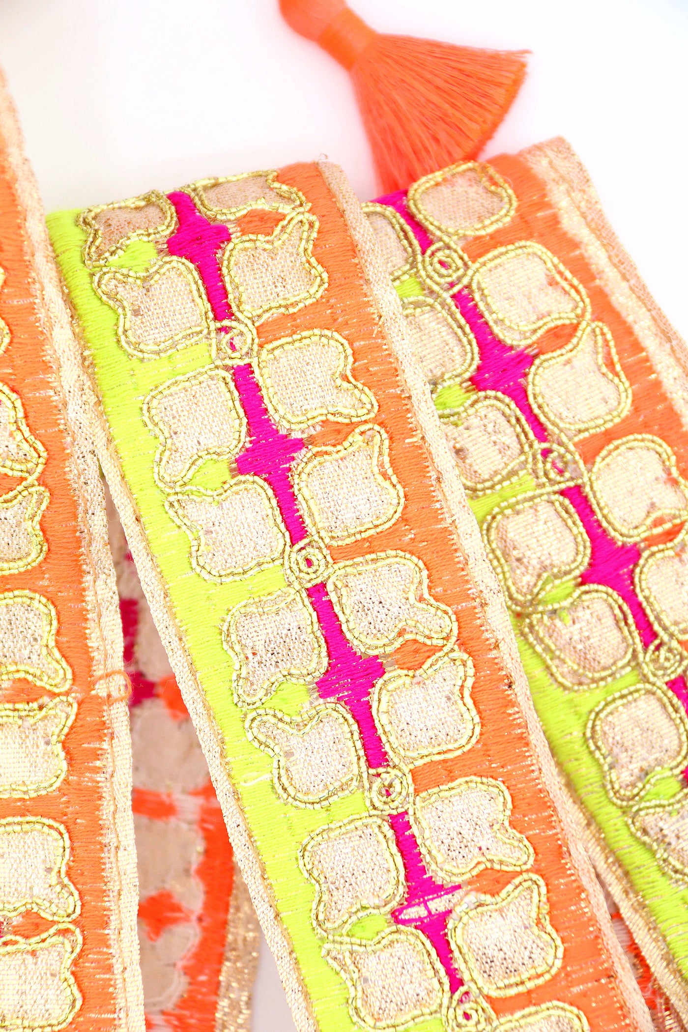 Neon embroidered sari trim with clover design and gold metallic thread. Great for sewing, crafting, embellishment, and DIY decor. Sold by the yard.