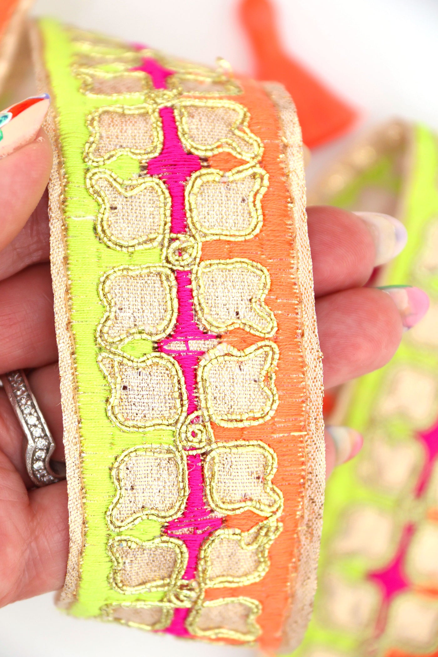 Neon embroidered sari trim with clover design and gold metallic thread. Great for sewing, crafting, embellishment, and DIY decor. Sold by the yard.