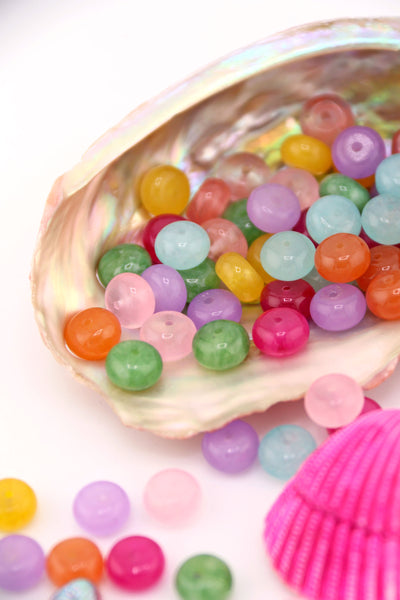 Pastel Rainbow Gemstone Beads, Loose Beads for DIY Necklace, shown spilling out of a large seashell.