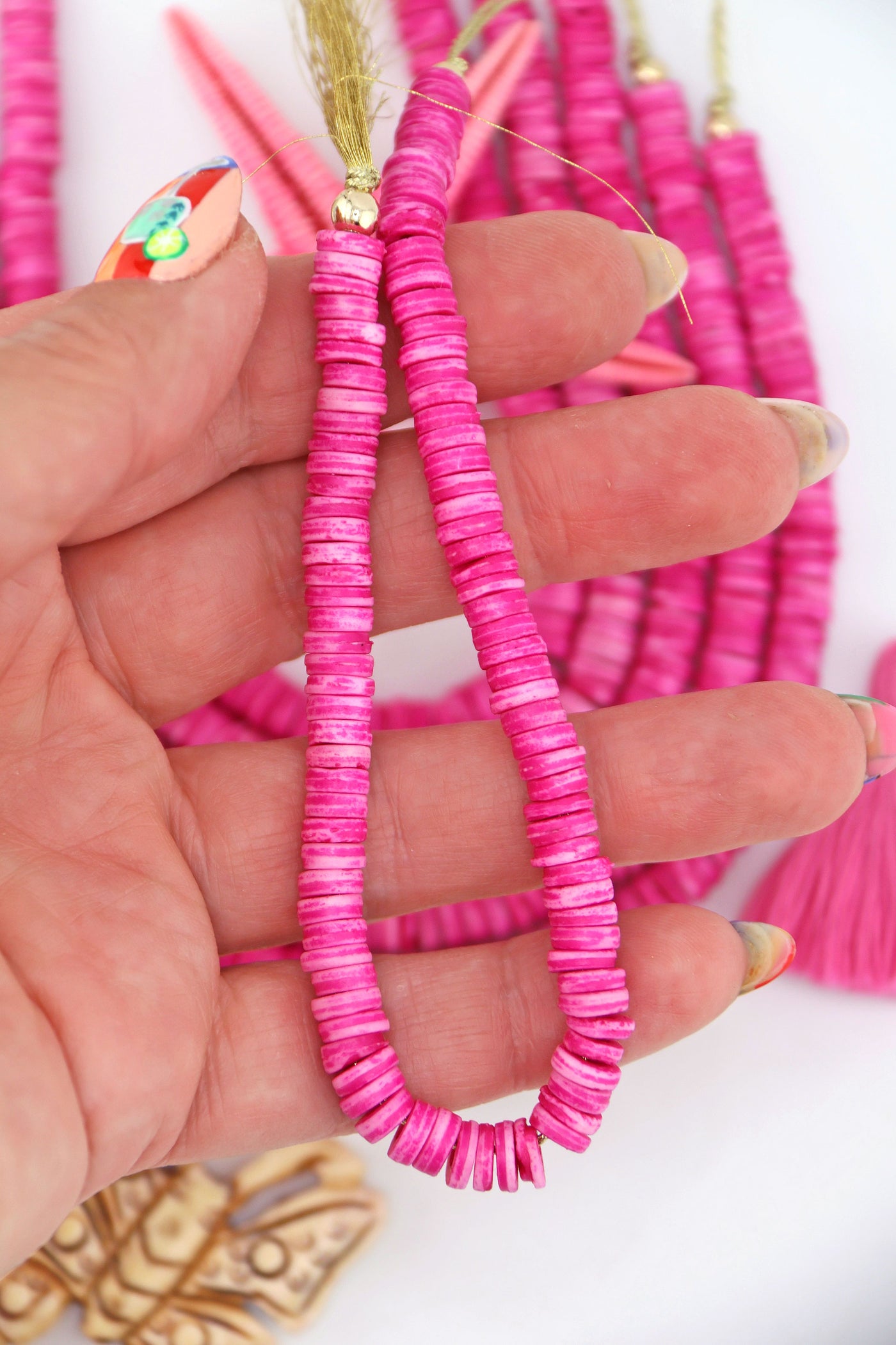 Bright Pink Bone Heishi Disc Beads, 7mm, 100+ beads on a strand, in the palm of a hand.