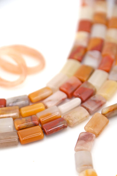 Earth-toned Sansha Jasper puffed rectangle beads arranged on white background, featuring gold, cream, and rust hues.
