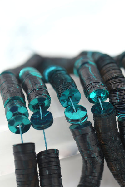 Vintage teal green sequins, approximately 6mm, shimmering with light reflection, perfect for jewelry making or sewing projects.